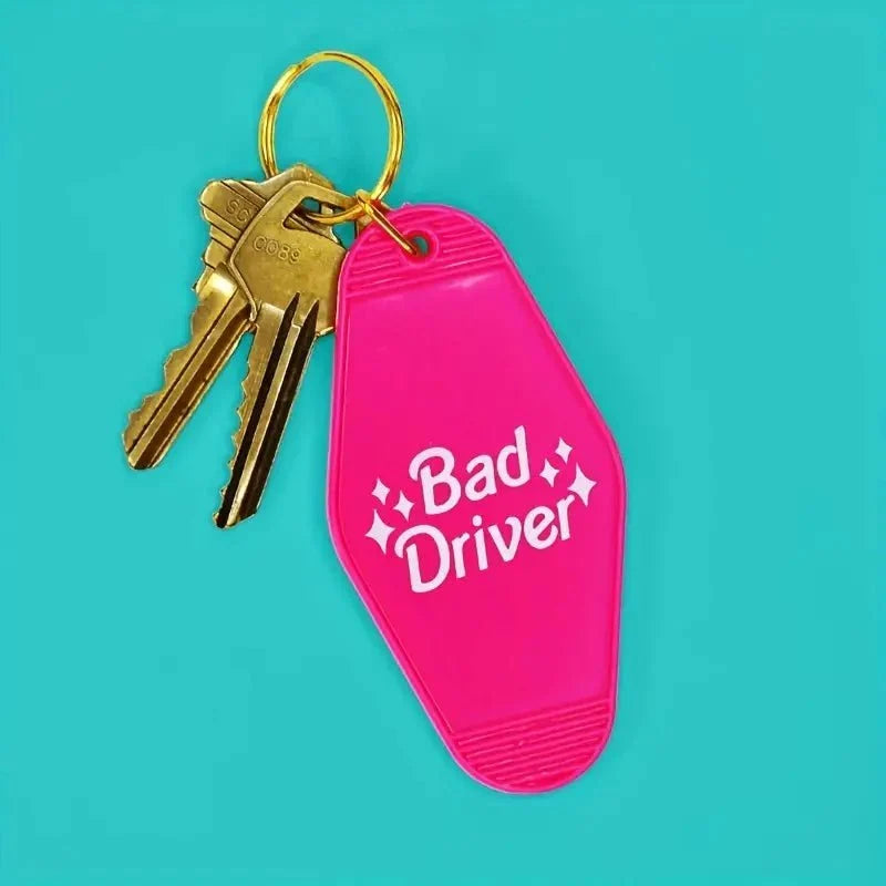 Funny Pink Bad Driver motel-style keychain tag with gold ring and two attached keys