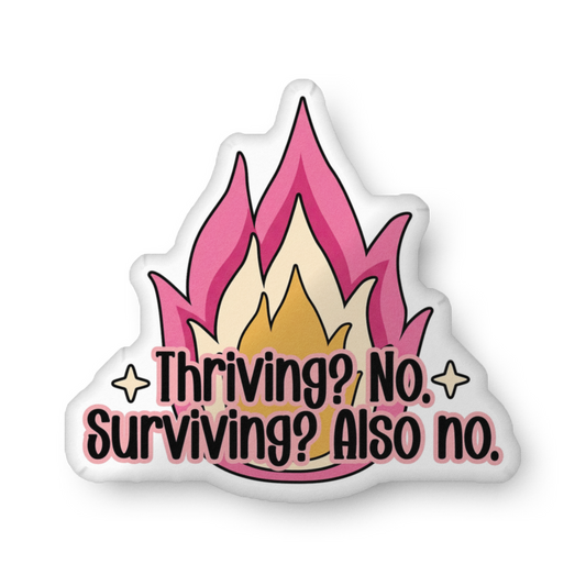 Custom-shaped pillow with pink flame graphic and 'Thriving? No, Surviving? Also no.'