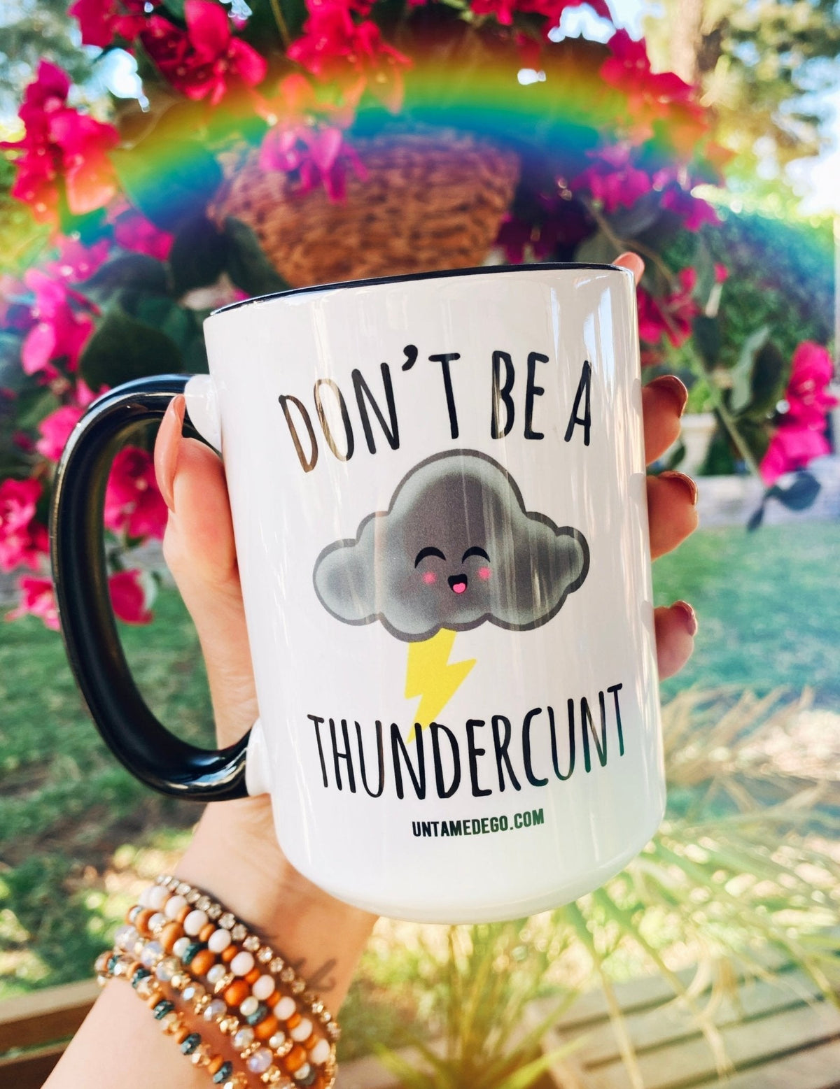 Funny "Don't Be A Thundercunt" — White mug held in hand, black handle and rim; cloud with lightning and 'Don't Be A Thundercunt'
