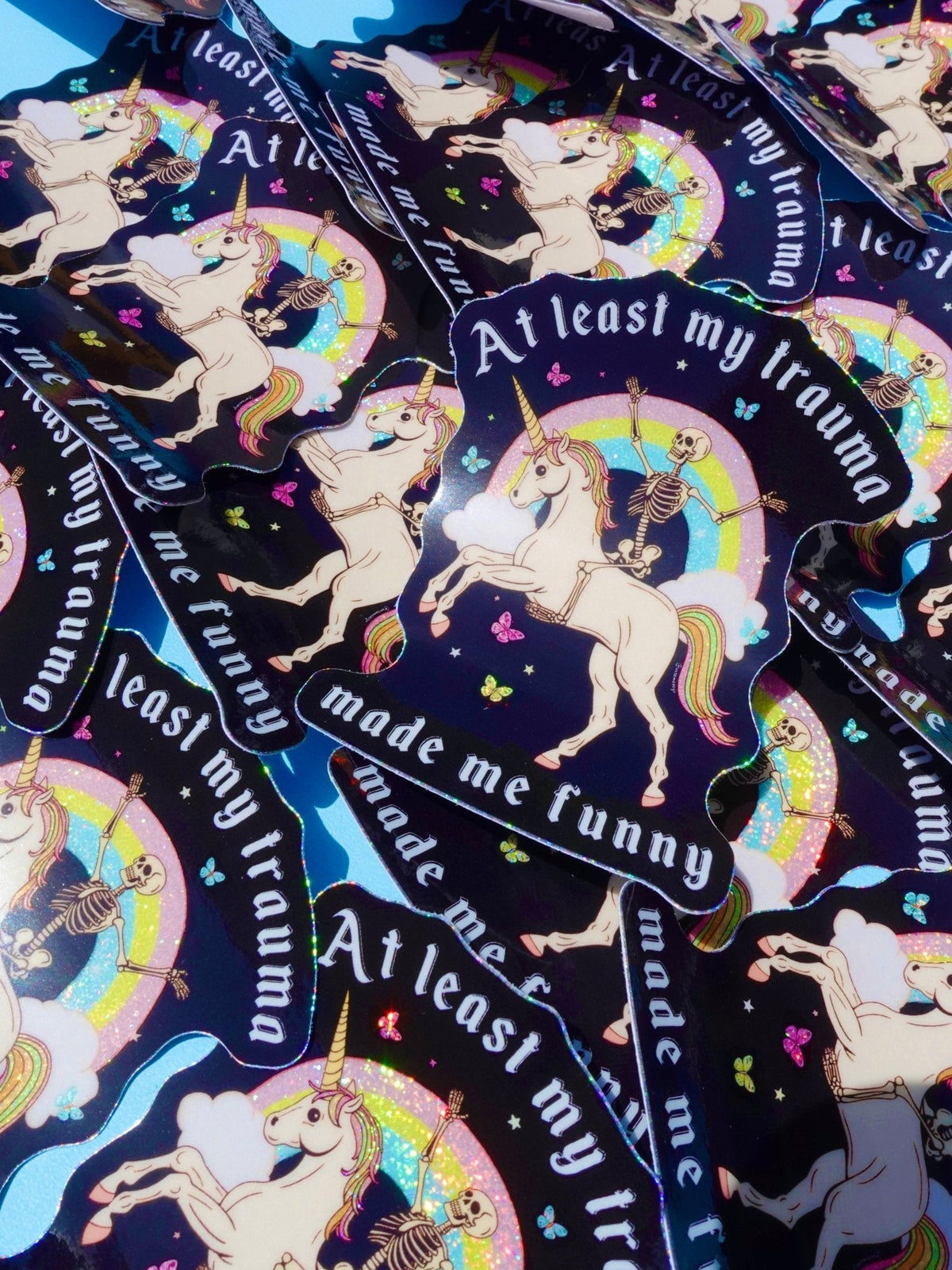 Set of black unicorn stickers with rainbow halos, skeleton figures, and 'made me funny' text