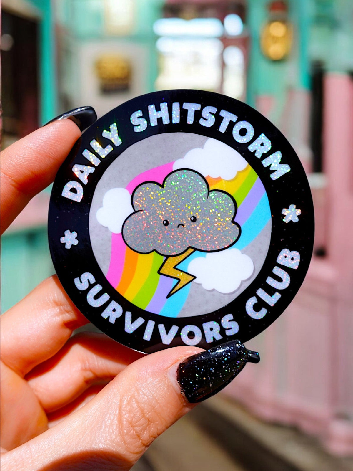 Funny Black round sticker held in hand with rainbow cloud and 'Survivors Club' text