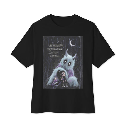 Black oversized boxy tee with the 'The Haunted' goth graphic: a little goth girl holding a candle beside a fuzzy blue monster under a crescent moon, with the words "Not everything that haunts you wants to hurt you"