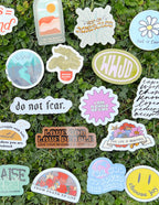 Variety of Christian Stickers featuring uplifting messages and vibrant designs on a grassy background