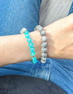 Two stone bracelets on wrist, featuring a Christian Jewelry Bracelet with 'HEAVEN' beads and another stone design