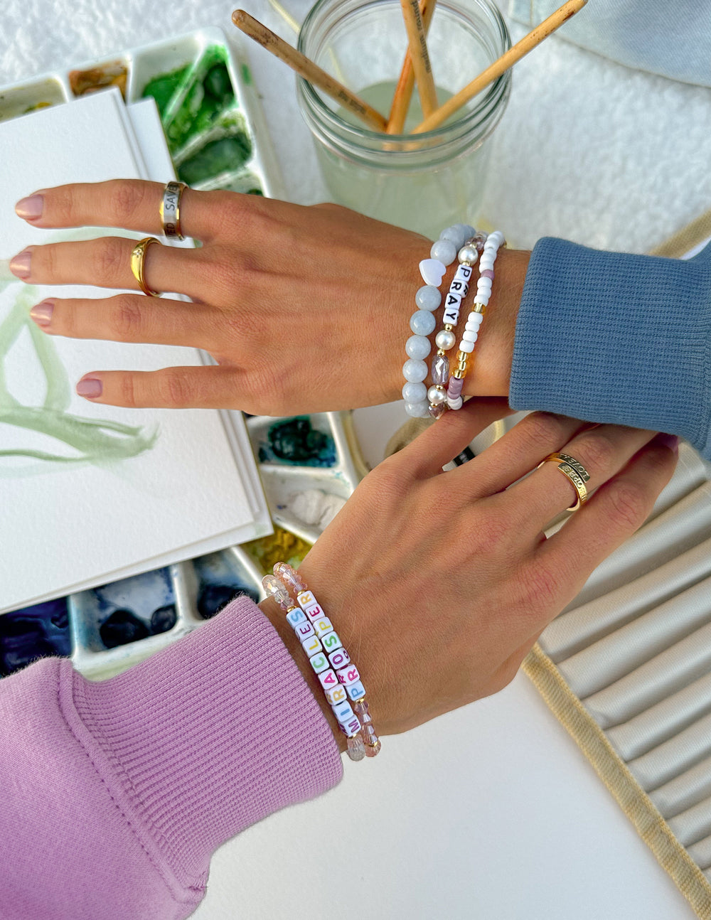 Elevated Faith Christian Jewelry Bracelet displayed on hands with colorful beaded patterns and personal letters