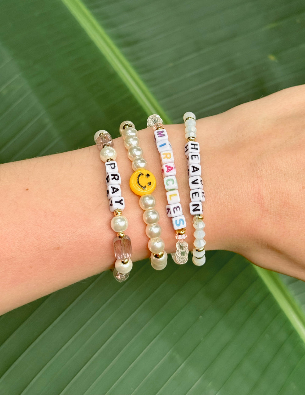 Set of colorful Elevated Faith Christian Jewelry Bracelets featuring letters and charm details