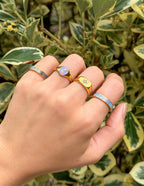 Hand wearing multiple Elevated Faith rings featuring colorful designs, perfect for Christian Jewelry enthusiasts