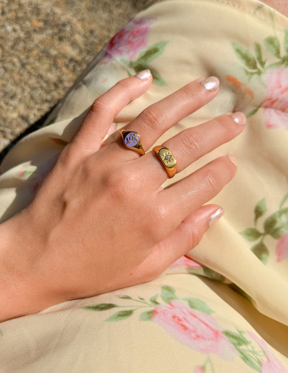 Elevated Faith Christian Jewelry featuring floral design rings displayed on a woman's hand in a floral dress
