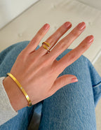 Elevated Faith Christian Jewelry Bracelet in Gold on a hand with a simple ring and casual denim outfit