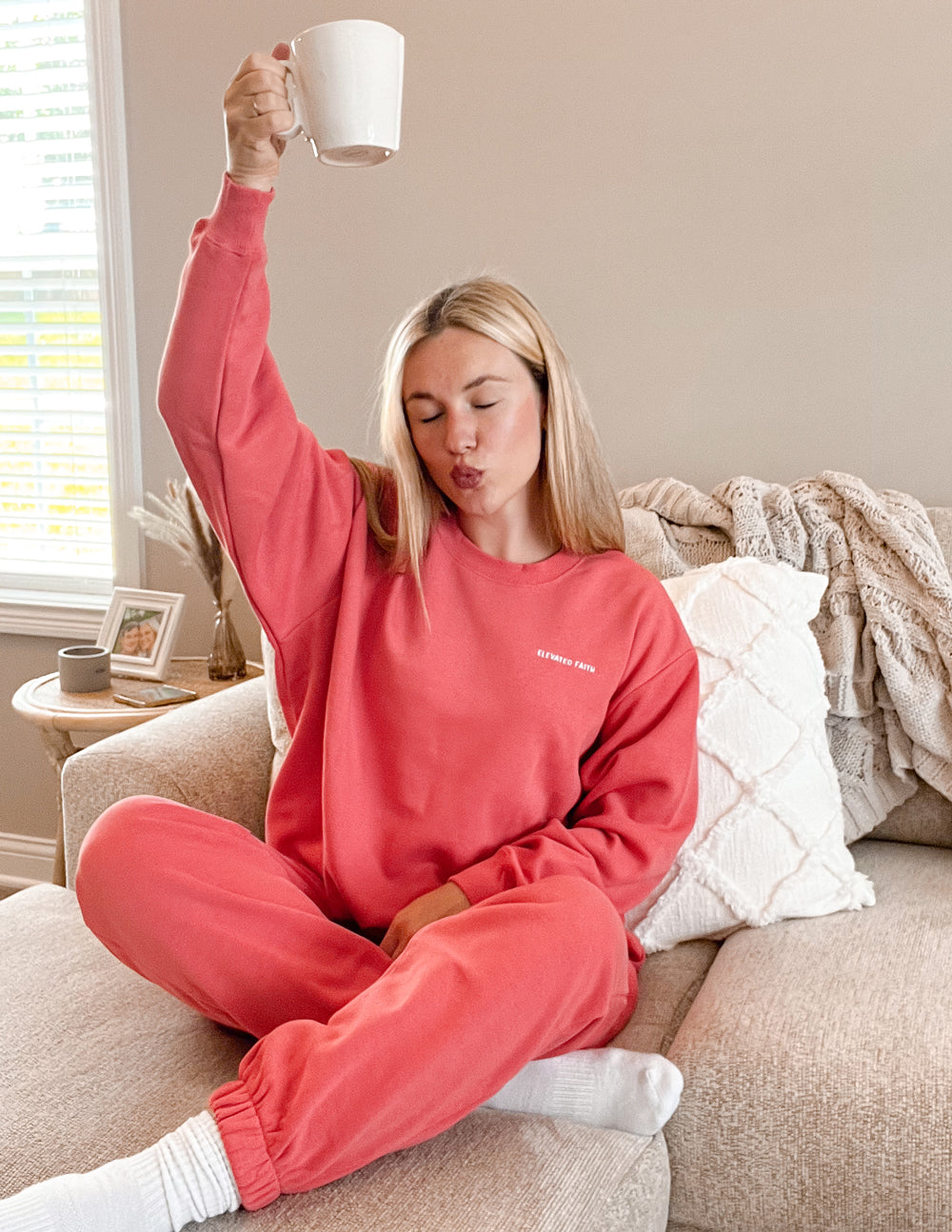 Comfortable Elevated Faith Christian Crewneck Sweatshirt in coral worn by a woman holding a mug