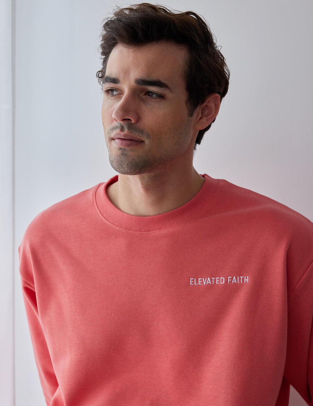 Elevated Faith Coral Christian Crewneck Sweatshirt featuring a simple logo for comfortable faith-based style