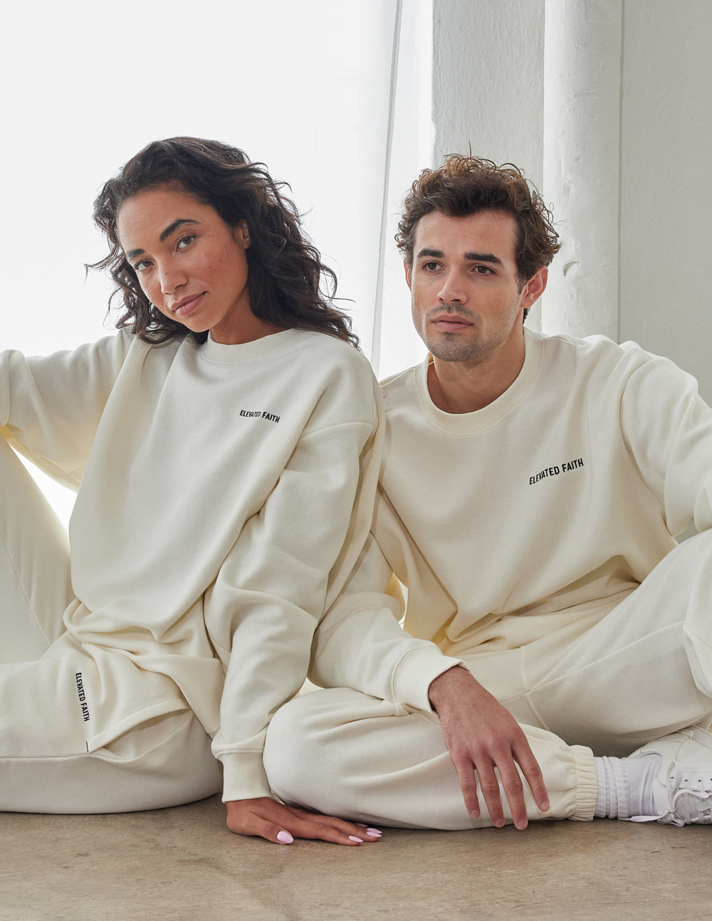 Couple wearing Elevated Faith Christian Crewneck Sweatshirt in off-white for casual comfort