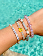 Stack of colorful Elevated Faith Christian Jewelry Bracelet with cross and smiley charm for a joyful look