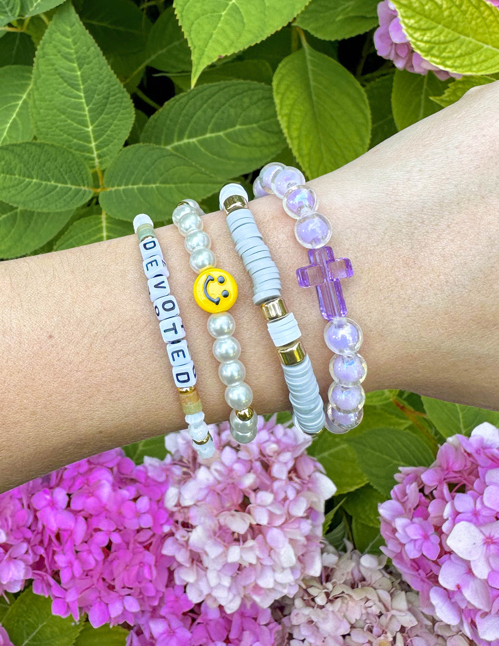 Collection of colorful Christian Jewelry Bracelets featuring beads and a cross charm on a wrist