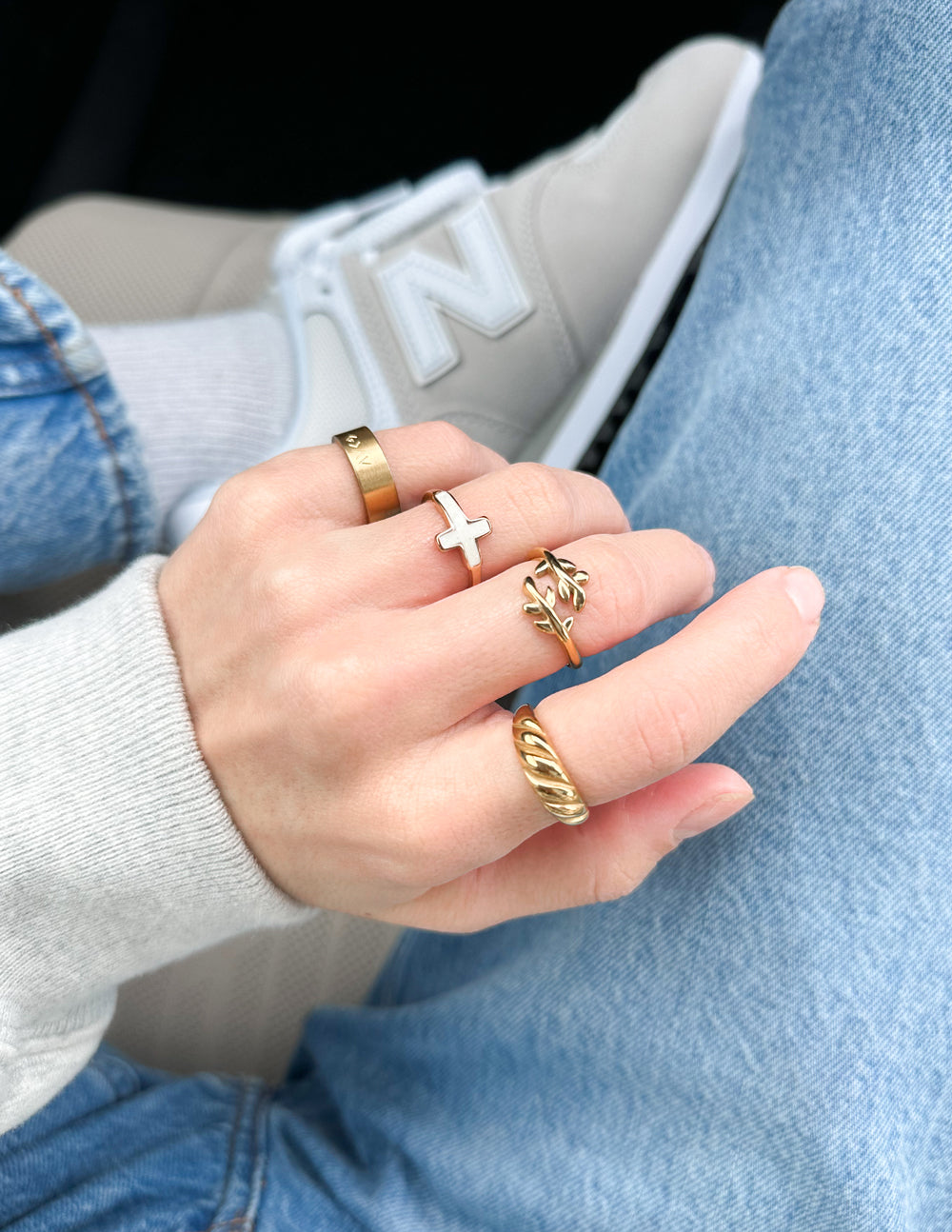 Elegant Elevated Faith Christian Jewelry rings styled together on a hand with denim and sneakers