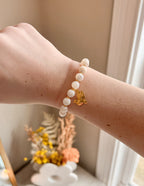 Elevated Faith Christian Jewelry Bracelet featuring white stones and a gold dove charm on a wrist