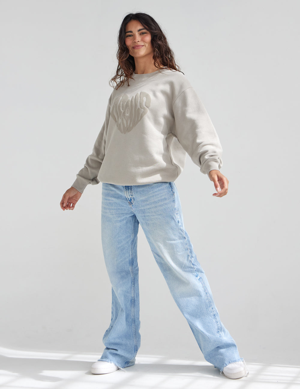 Elevated Faith Christian Crewneck Sweatshirt in beige, styled with light blue jeans for a casual look