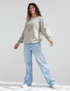 Elevated Faith Christian Crewneck Sweatshirt in beige, styled with light blue jeans for a casual look