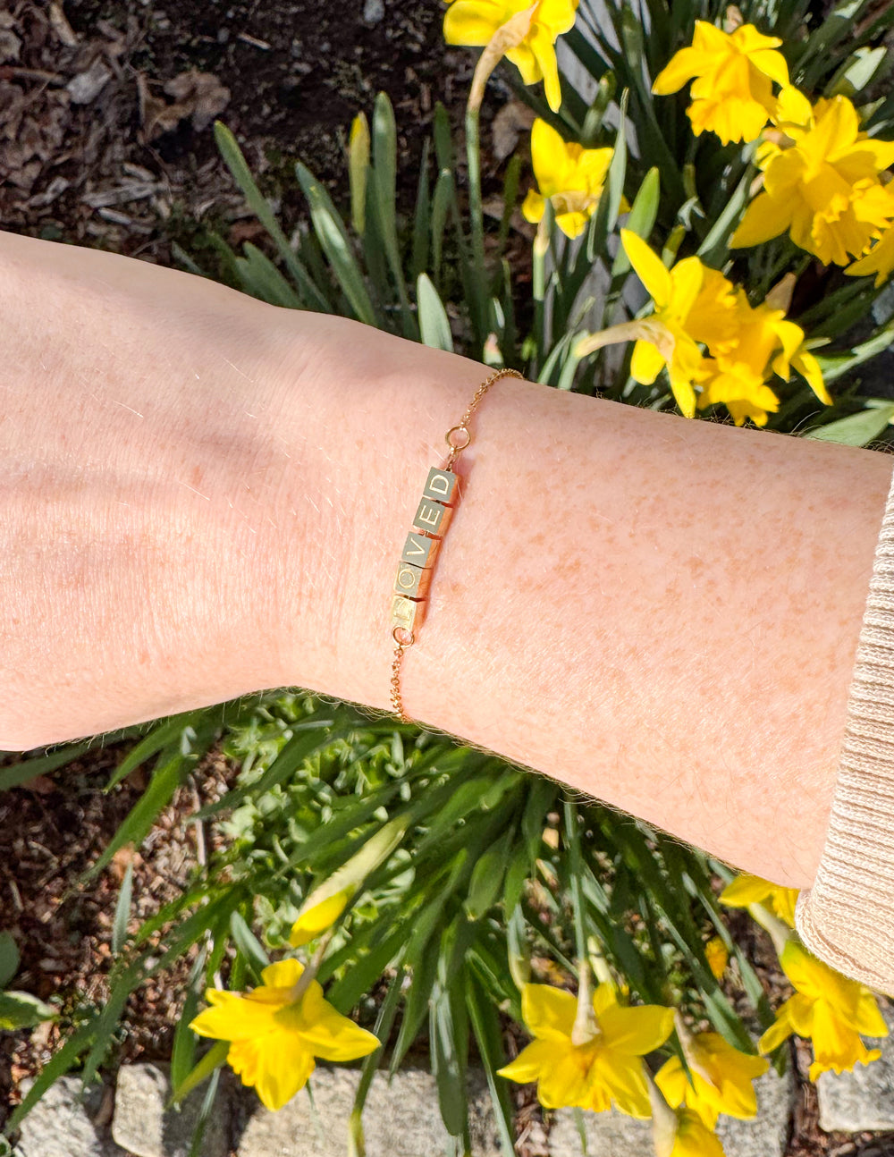 Elevated Faith Christian Jewelry Bracelet displayed on a wrist with a floral background