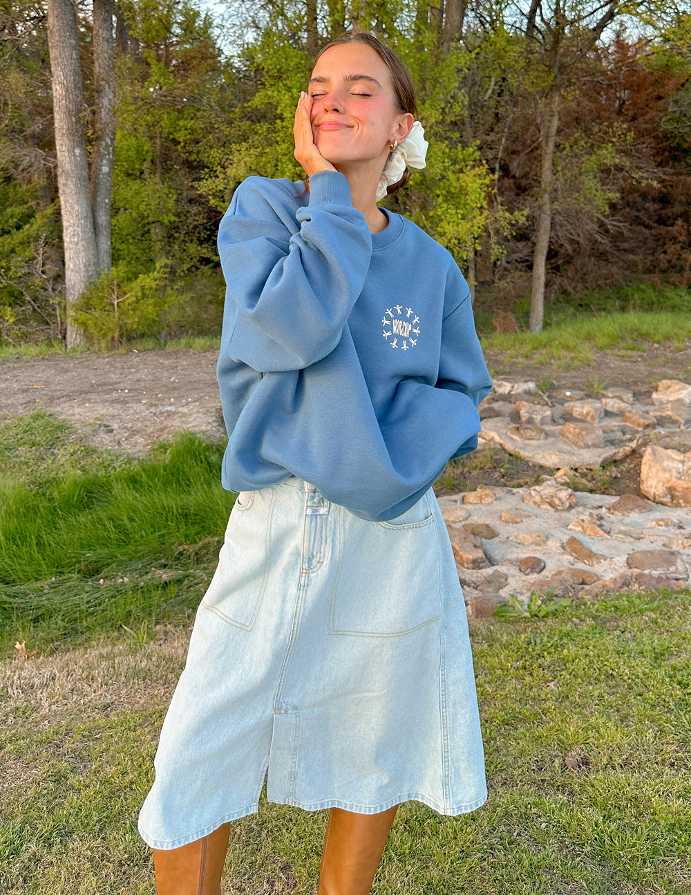 Elevated Faith Christian Crewneck Sweatshirt in blue, styled with a denim skirt outdoors