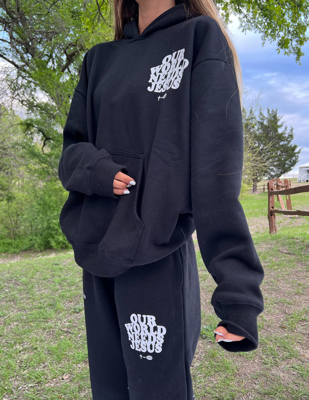 Elevated Faith black sweatpants with 'Our World Needs Jesus' print, perfect for Christian Apparel.