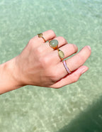 Elevated Faith Christian Jewelry rings in gold and silver worn on hand by the water