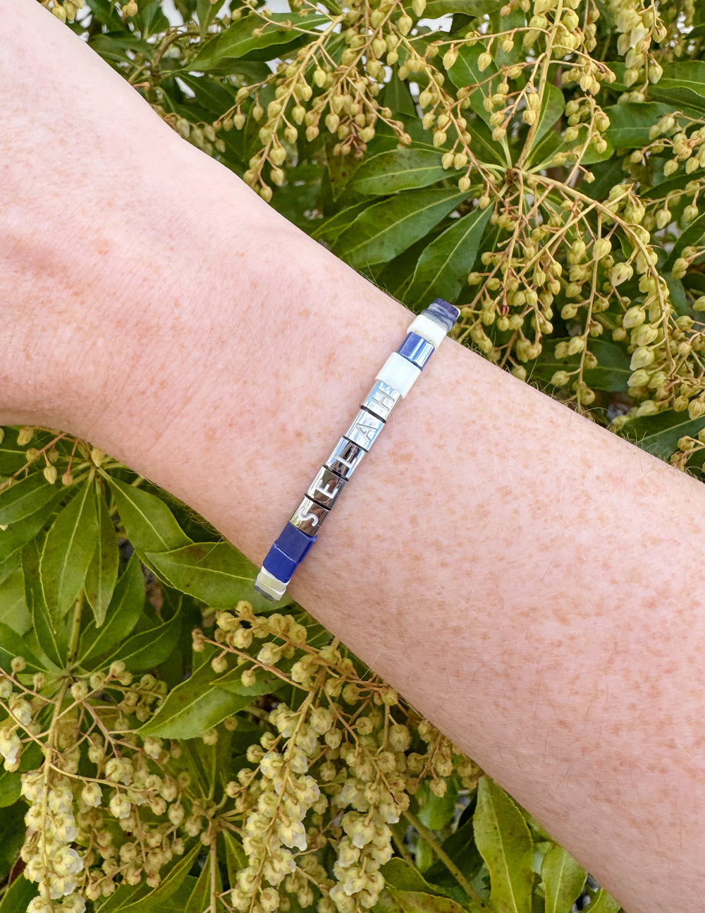 Elevated Faith Christian Jewelry Bracelet with colorful letter beads on a wrist against a natural background