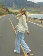 Woman wearing a Christian Crewneck Sweatshirt while walking on a scenic road surrounded by mountains