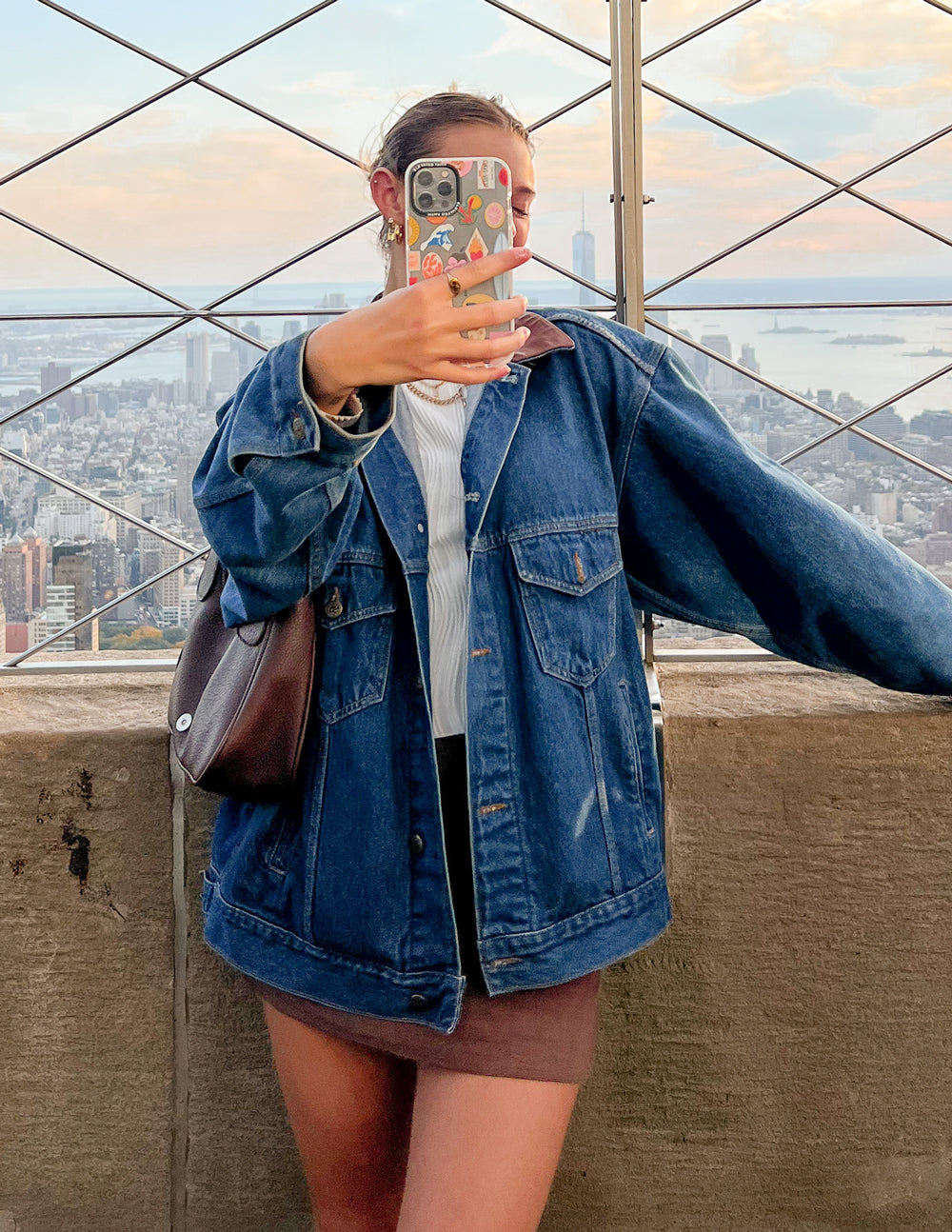 Elevated Faith Christian iPhone Case held in hand with skyline view in the background