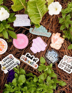 Assorted Christian Stickers on a bed of pine needles with vibrant designs and uplifting messages