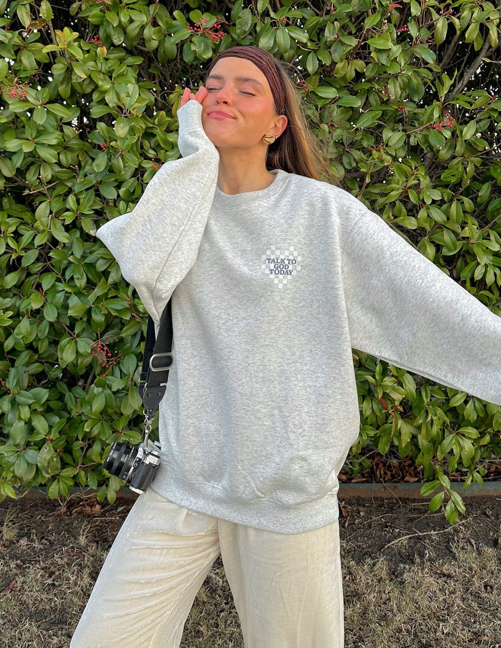 Woman in a gray Christian Crewneck Sweatshirt with oversized fit and relaxed style outdoors