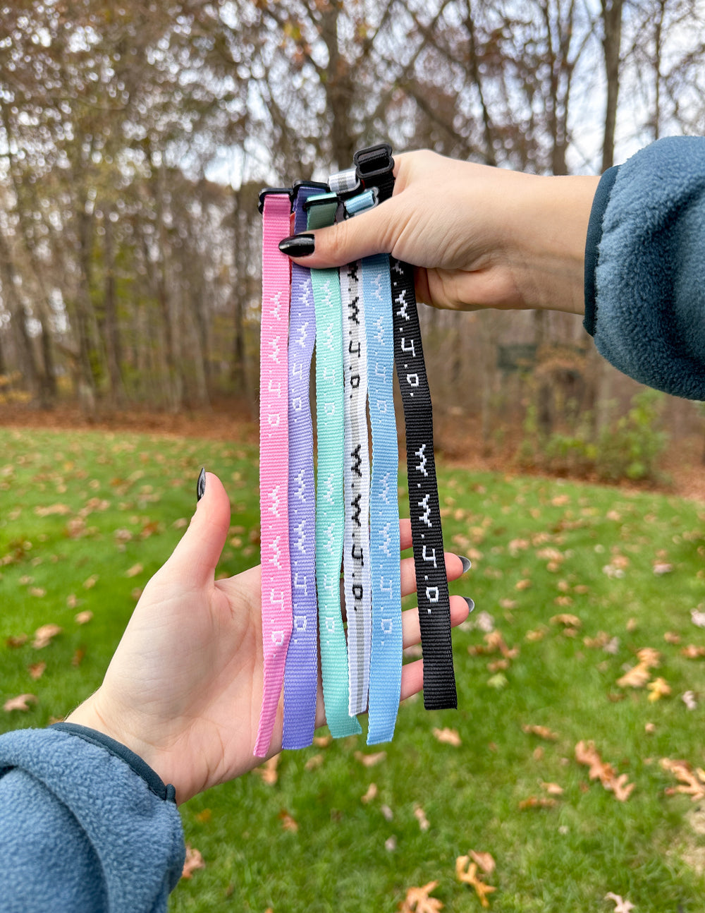 Colorful Elevated Faith Christian Jewelry Bracelet wristbands held outdoors with a vibrant background