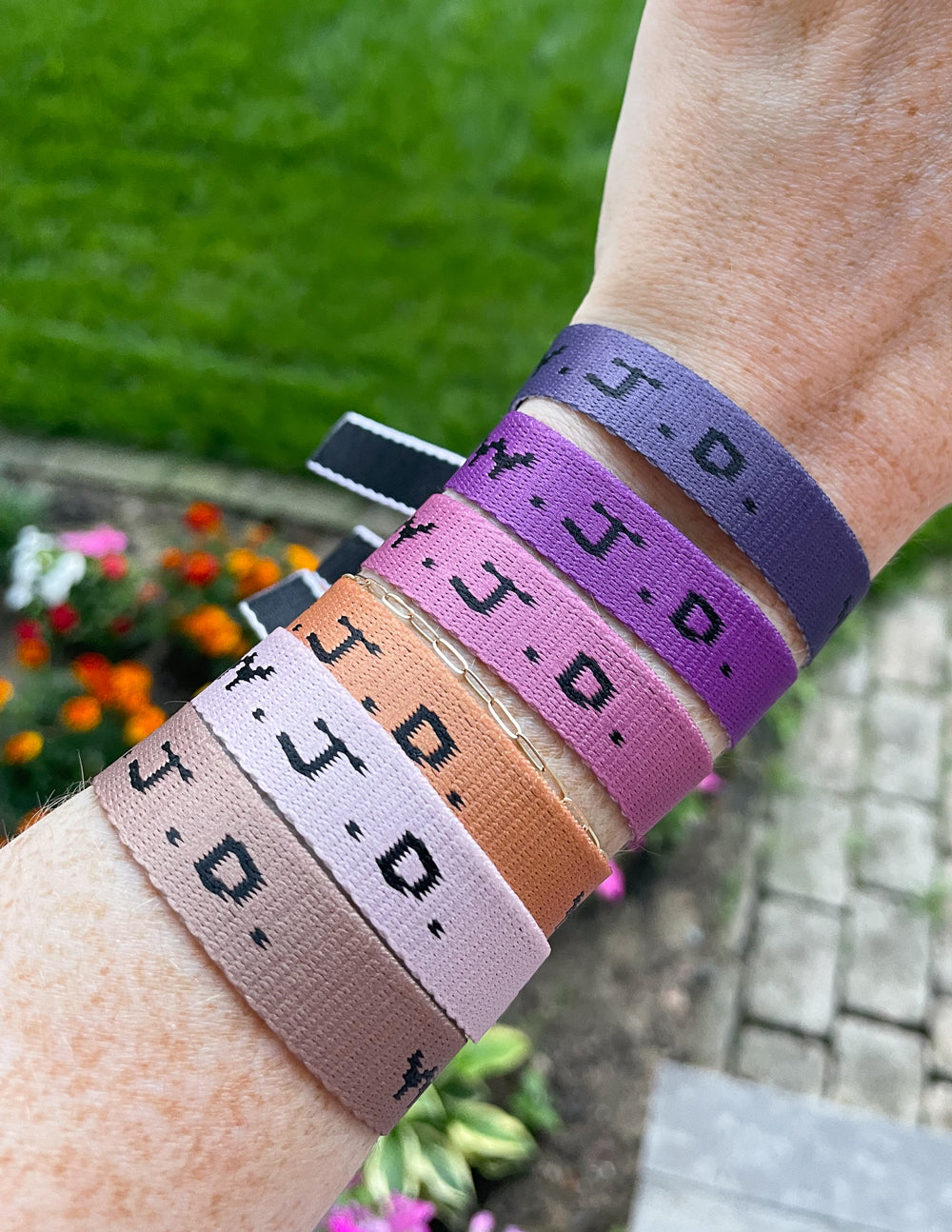 Colorful Elevated Faith Christian Jewelry Bracelet wristbands worn on a person's arm outdoors