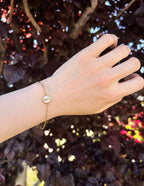 Gold Christian Jewelry Bracelet on a hand, featuring a simple design against a flowered background