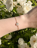 Elevated Faith Christian Jewelry Bracelet featuring a delicate design on a wrist amidst blooming flowers