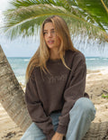 Elevated Faith Christian Crewneck Sweatshirt in brown with YHWH design on a beach setting