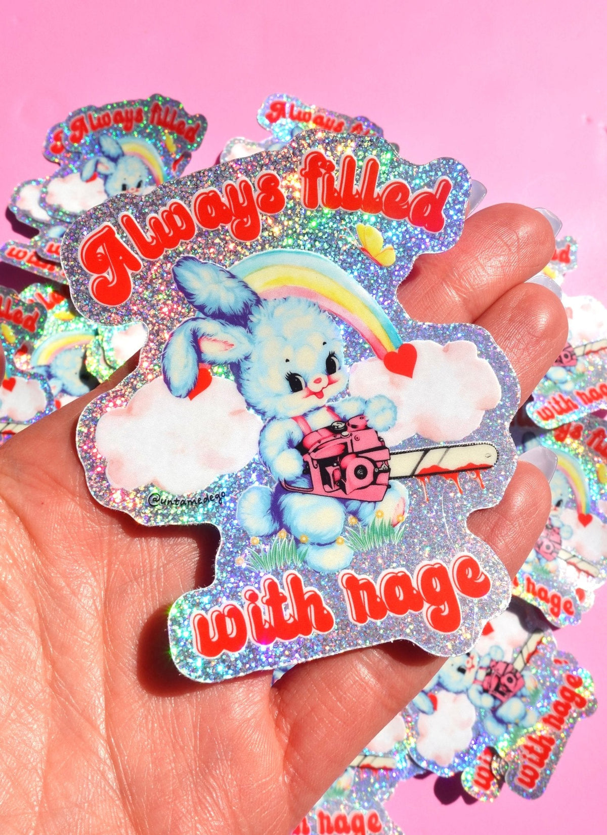 Funny Glitter holographic bunny rainbow sticker in hand, with clouds and red slogan text