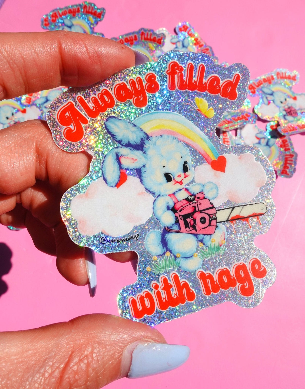 Funny Glitter holographic bunny sticker with rainbow clouds and hearts, held between fingers