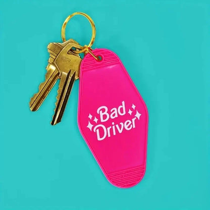 Funny Pink Bad Driver motel-style keychain tag with gold ring and two attached keys
