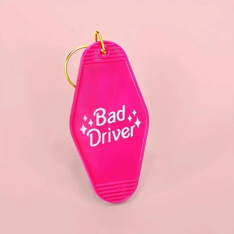 Funny Pink Bad Driver motel-style keychain tag with gold ring and hook