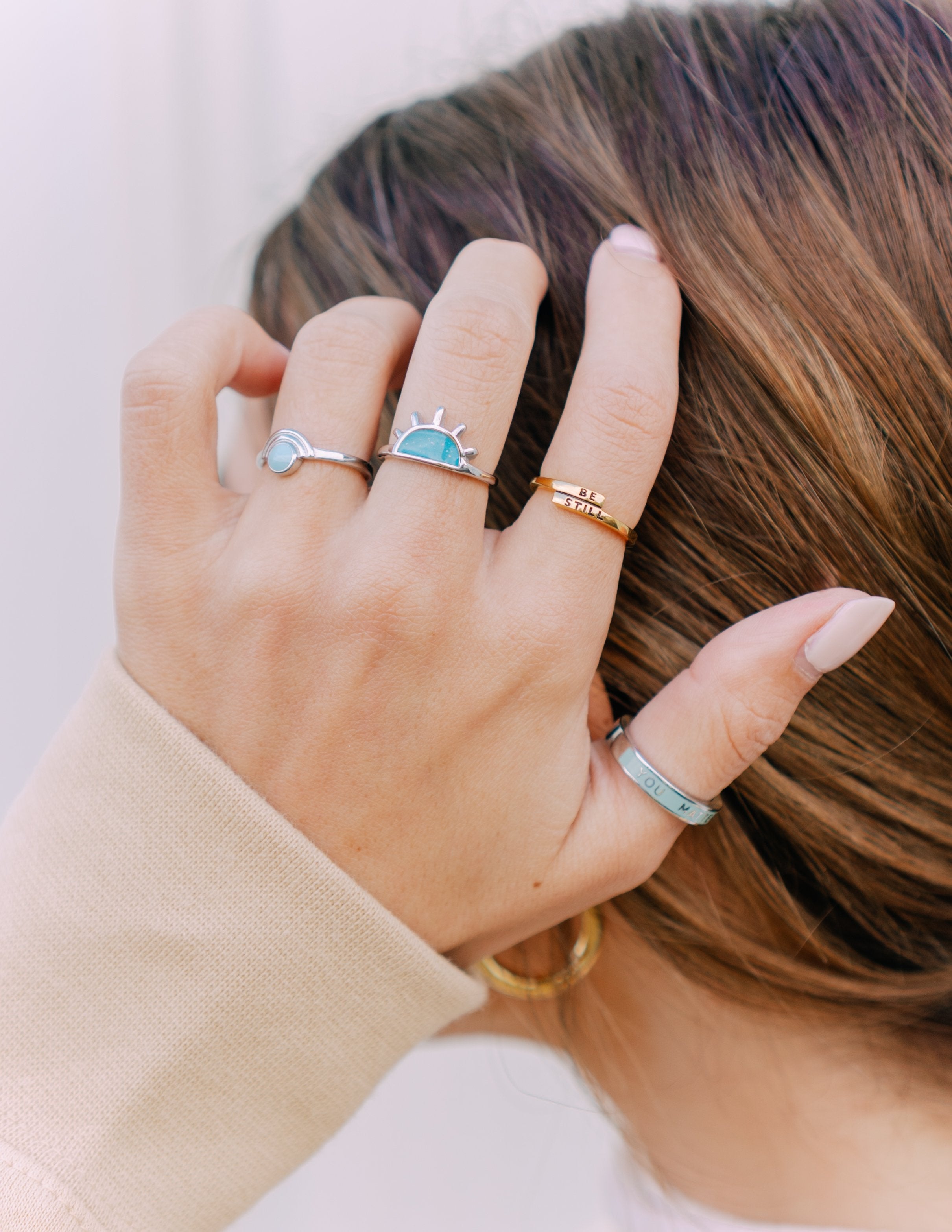 Elevated Faith Christian Jewelry rings displayed on a hand with a stylish design and various colors