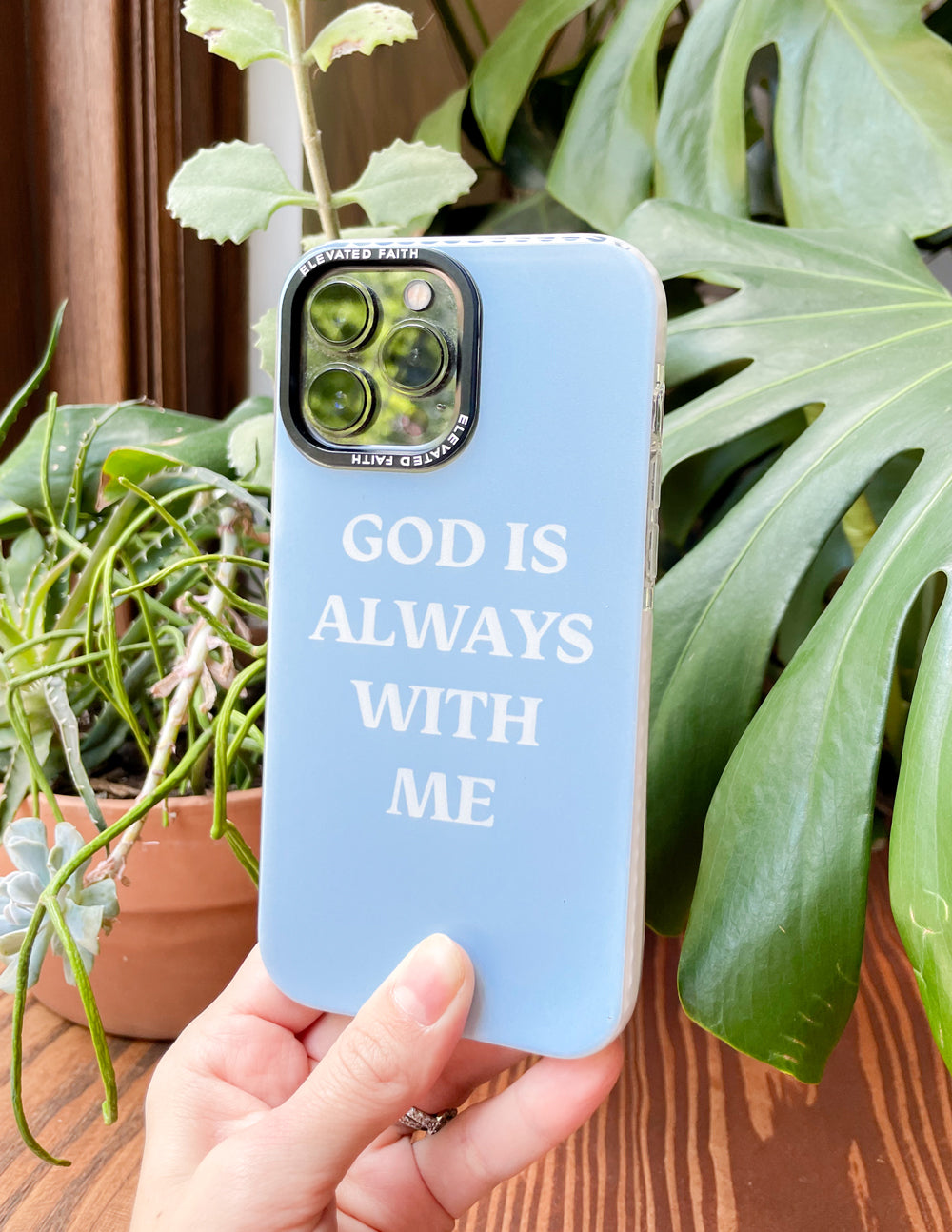 Elevated Faith Christian iPhone Case featuring the text God is Always With Me on a light blue background