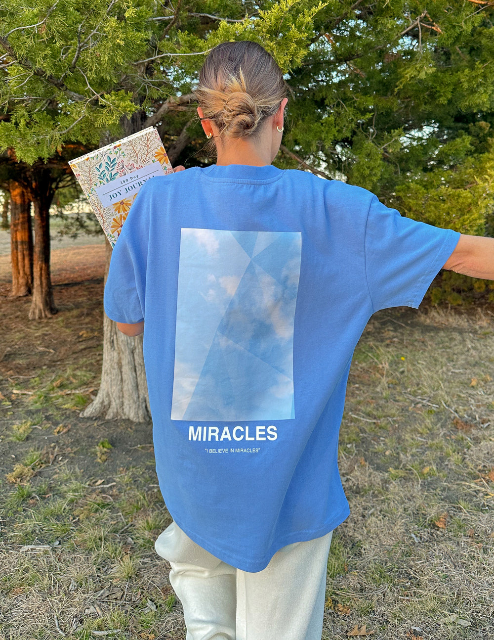 Elevated Faith Blue Christian Apparel T-Shirt with MIRACLES graphic on the back