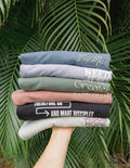 Stack of Elevated Faith Christian Apparel T-Shirts in various colors and messages promoting faith