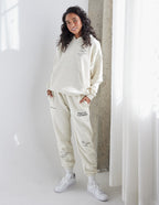Model wearing a cream Elevated Faith Christian Hoodie with matching sweatpants for a stylish look
