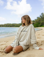 Elevated Faith Christian Hoodie in light beige with beach backdrop for a relaxed, stylish look