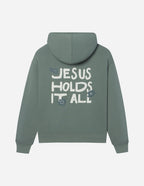 Elevated Faith Christian Hoodie in green with 'Jesus Holds It All' graphic on the back