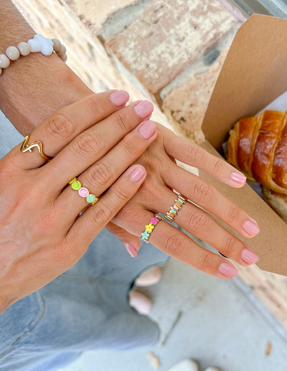 Two hands showcasing colorful Christian Jewelry rings from Elevated Faith, perfect for everyday wear