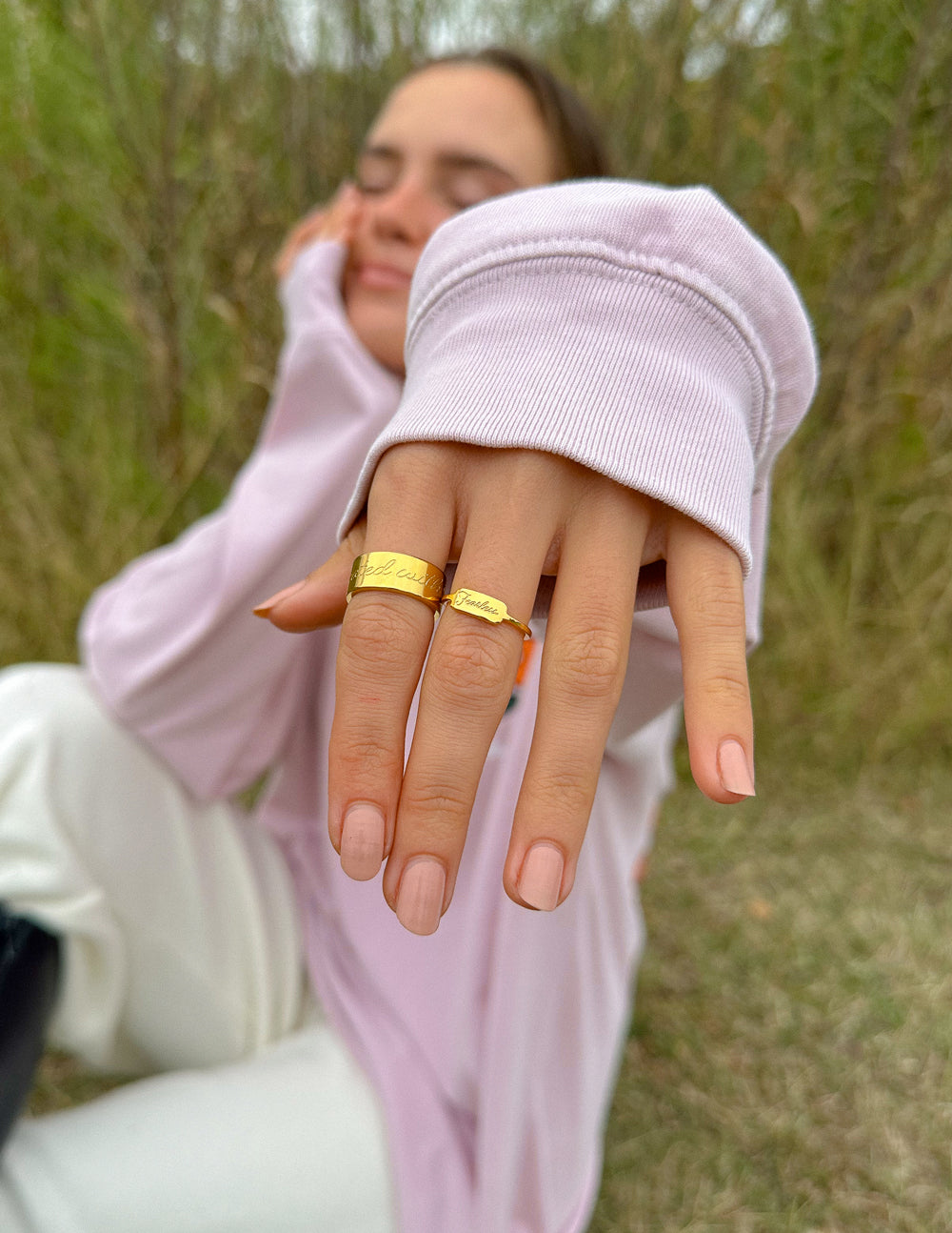 Elevated Faith Christian Jewelry gold ring worn on fingers outdoors with soft focus background