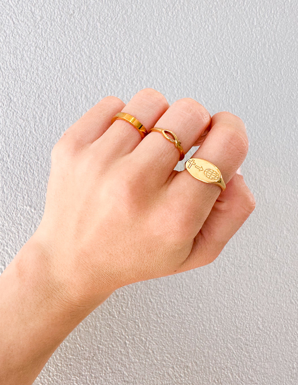 Gold Elevated Faith Christian Jewelry rings featuring unique designs on a hand model
